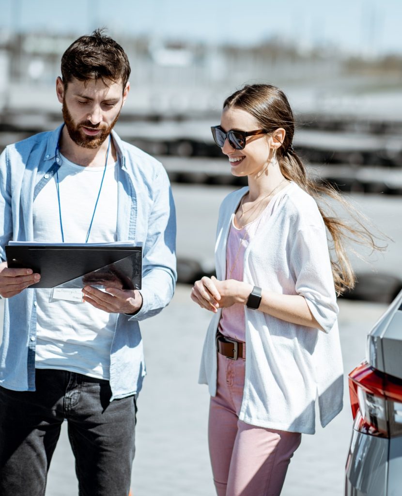 Instructor with female student at the driving school outdooors
